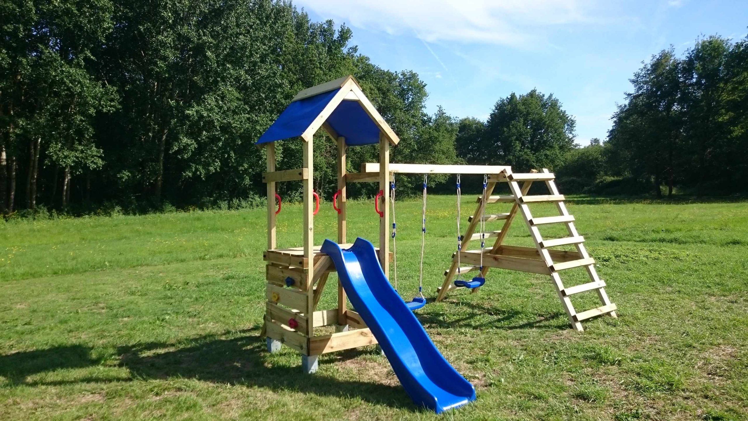 DSC_2351 Aire de jeux en bois avec toboggan bleu, idéale pour un hébergement insolite en pleine nature.