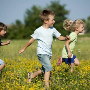 Hébergement insolite en pleine nature, enfants jouant dans un champ de fleurs.
