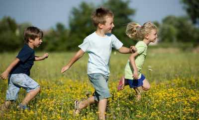 Hébergement insolite en pleine nature, enfants jouant dans un champ de fleurs.
