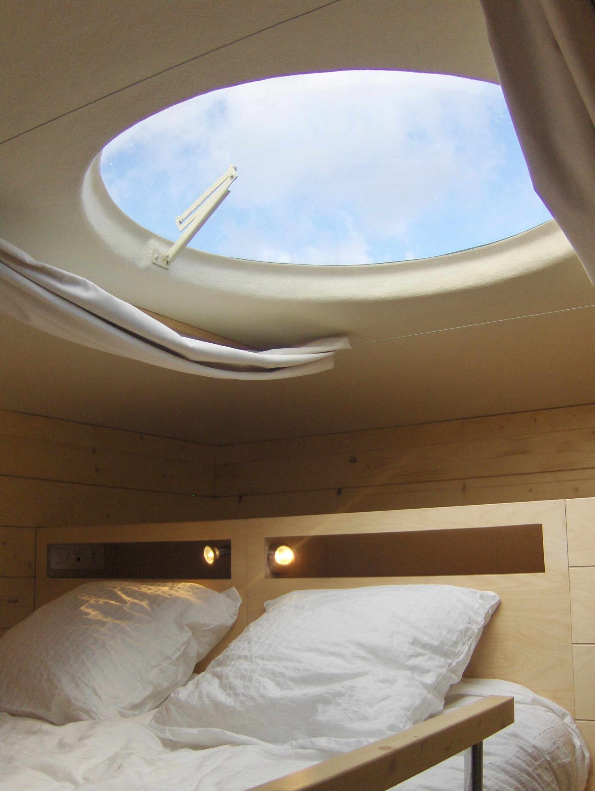 Lit carre d'etoiles Hébergement insolite en cabane avec un puits de lumière offrant une vue sur le ciel.