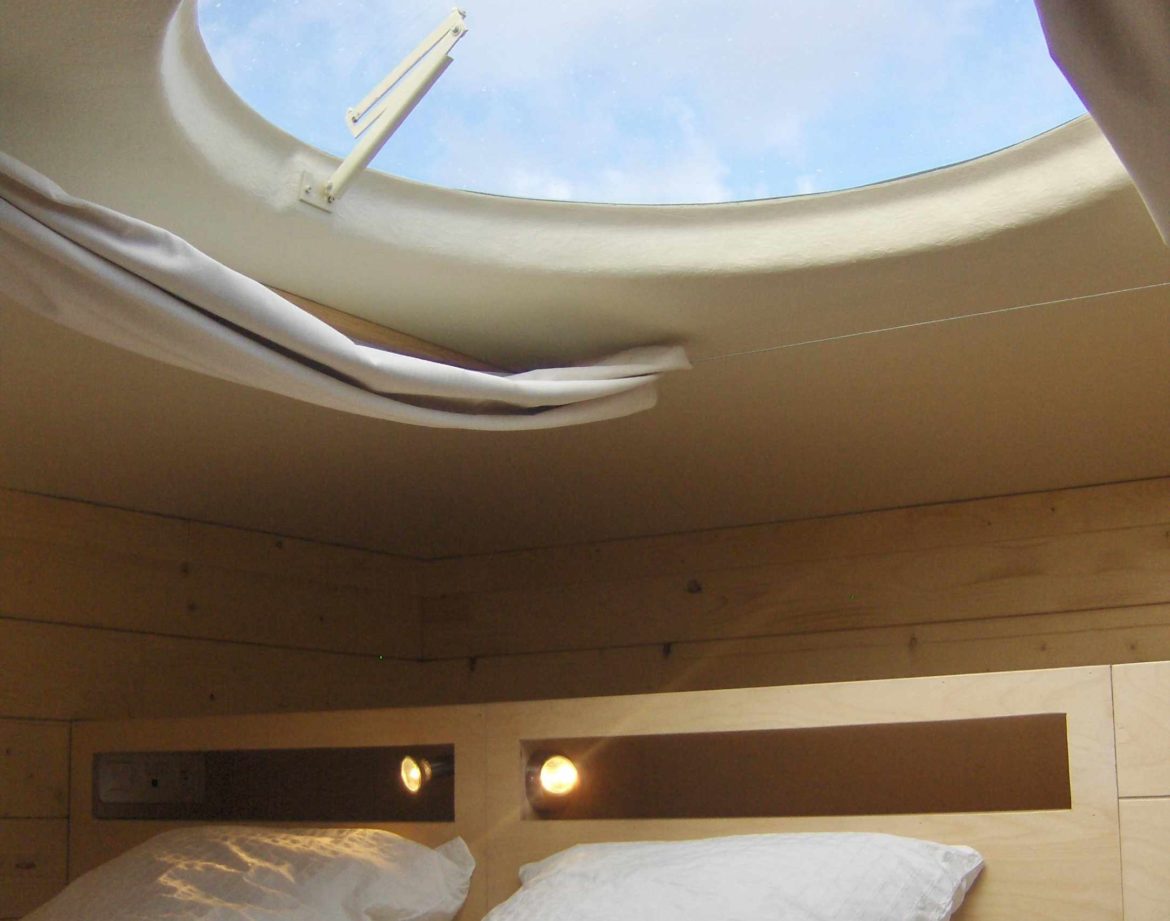 Hébergement insolite en cabane avec un puits de lumière offrant une vue sur le ciel.