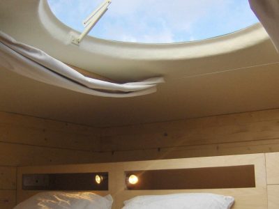 Hébergement insolite en cabane avec un puits de lumière offrant une vue sur le ciel.