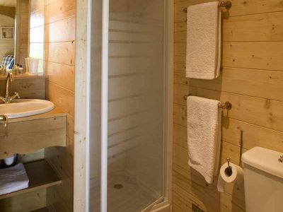 Salle de bain en bois dans un hébergement insolite au Centre, avec douche et lavabo.