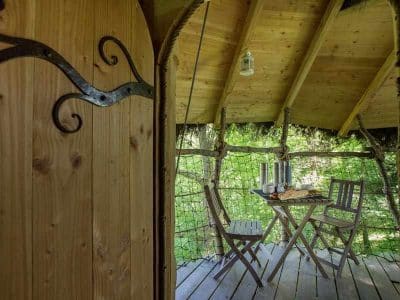 Cabane perchée en Basse-Normandie avec table en bois et vue sur la nature.