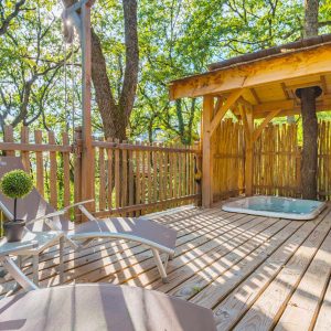 Cabane perchée en Aquitaine avec terrasse en bois et jacuzzi. Ambiance nature apaisante.