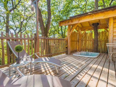 Cabane perchée en Aquitaine avec terrasse en bois et jacuzzi. Ambiance nature apaisante.