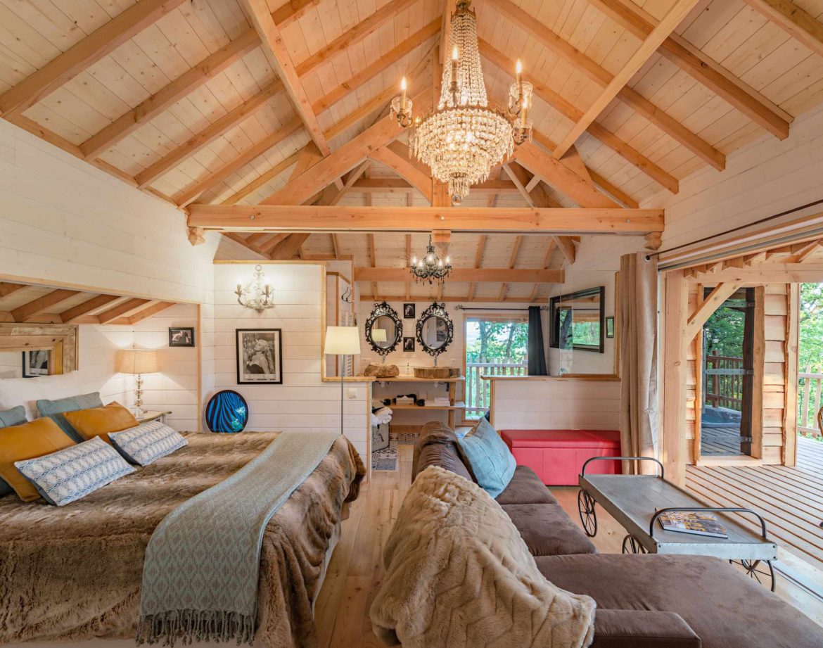 Chalet en bois élégant avec un lustre, offrant une vue sur la nature en Aquitaine.