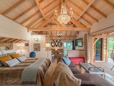 Chalet en bois élégant avec un lustre, offrant une vue sur la nature en Aquitaine.