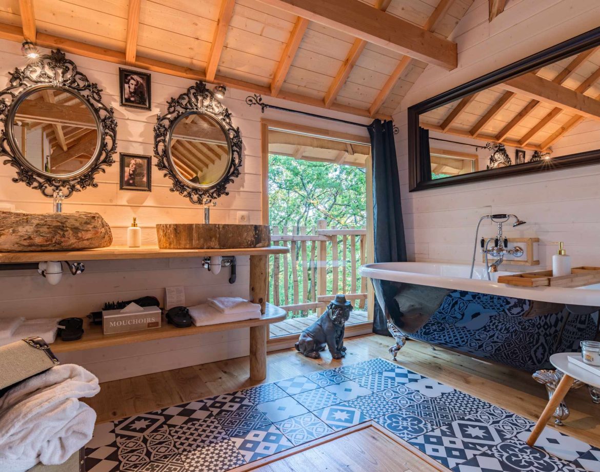 Hébergement insolite en Aquitaine : chalet en bois avec baignoire vintage et décor élégant.