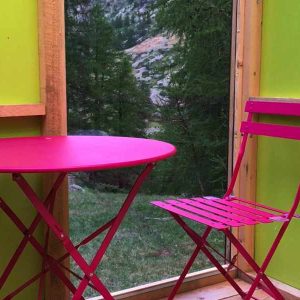 Cabane colorée en Provence-Alpes-Côte dAzur avec table et chaise roses.