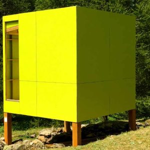 Cabane moderne jaune sur pilotis, entourée de verdure en Provence-Alpes-Côte dAzur.