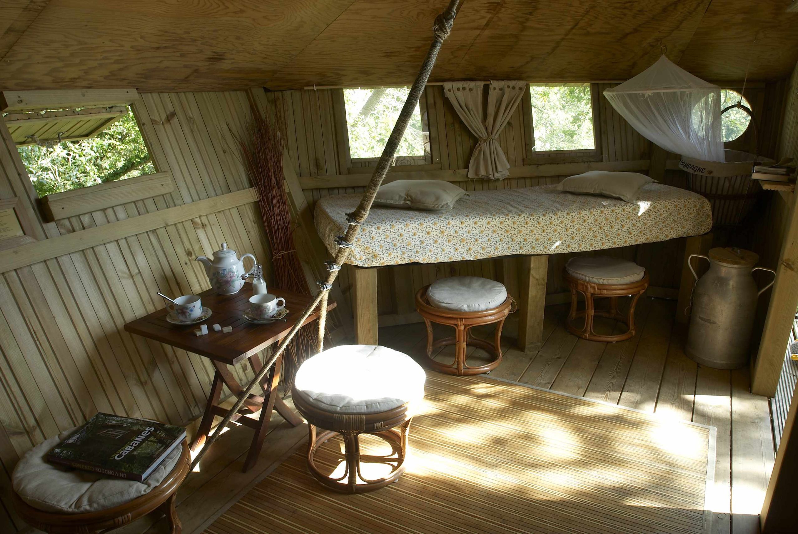 Angle petit lit belle lumiere Cabane en bois en Bretagne, avec lit douillet et coin salon lumineux.