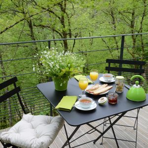 Hébergement insolite en Limousin : petit-déjeuner sur une terrasse verdoyante.