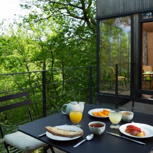 Hébergement insolite en cabane dans les arbres, petit-déjeuner sur la terrasse verdoyante.