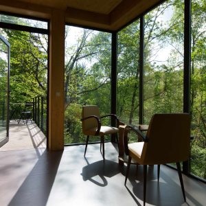Hébergement insolite en Limousin : chalet en bois avec grandes baies vitrées et vue sur la nature.