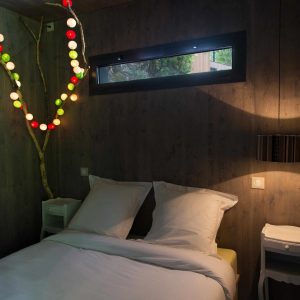 Chambre cocooning en bois avec guirlande lumineuse colorée à Limousin.