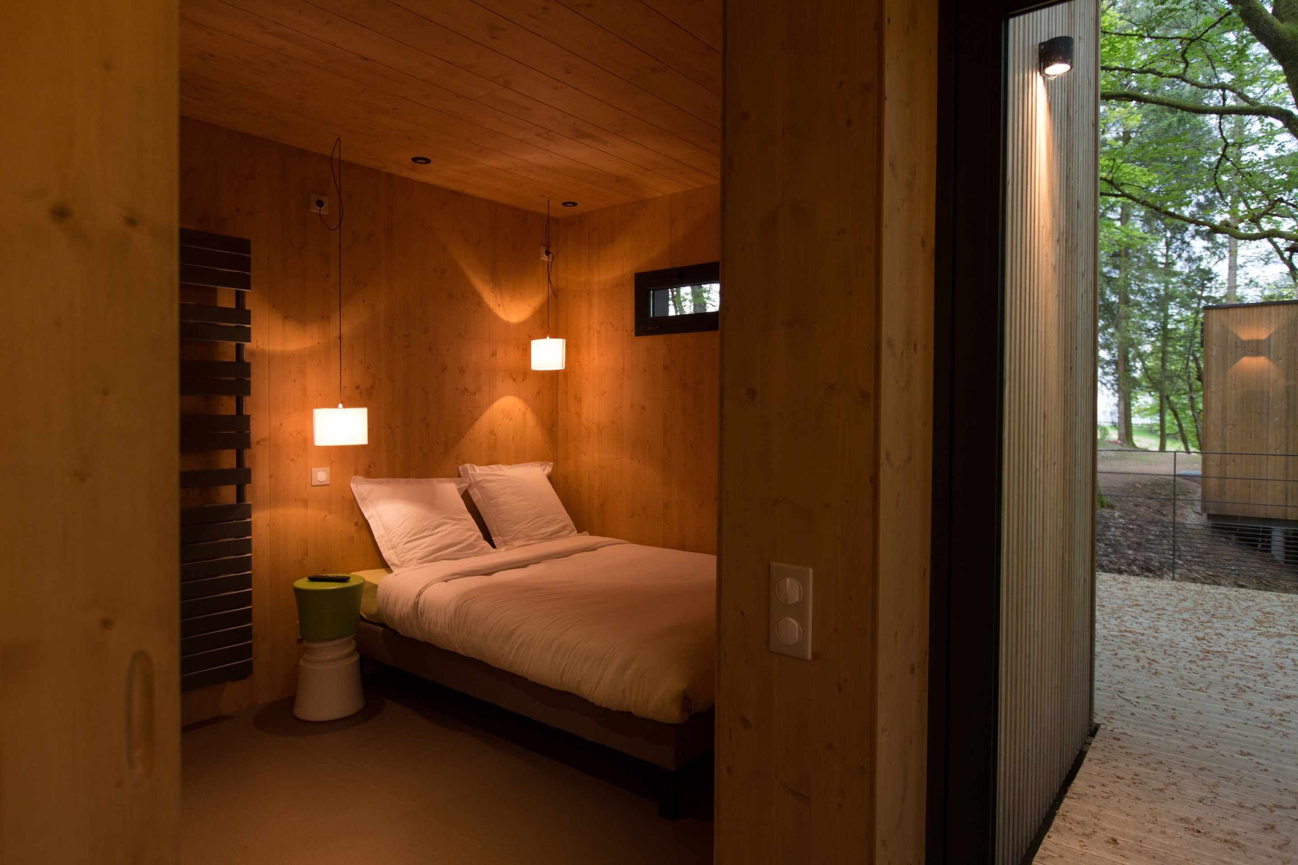 E98A7940 Chalet moderne en bois à Limousin, avec lit douillet et éclairage chaleureux.