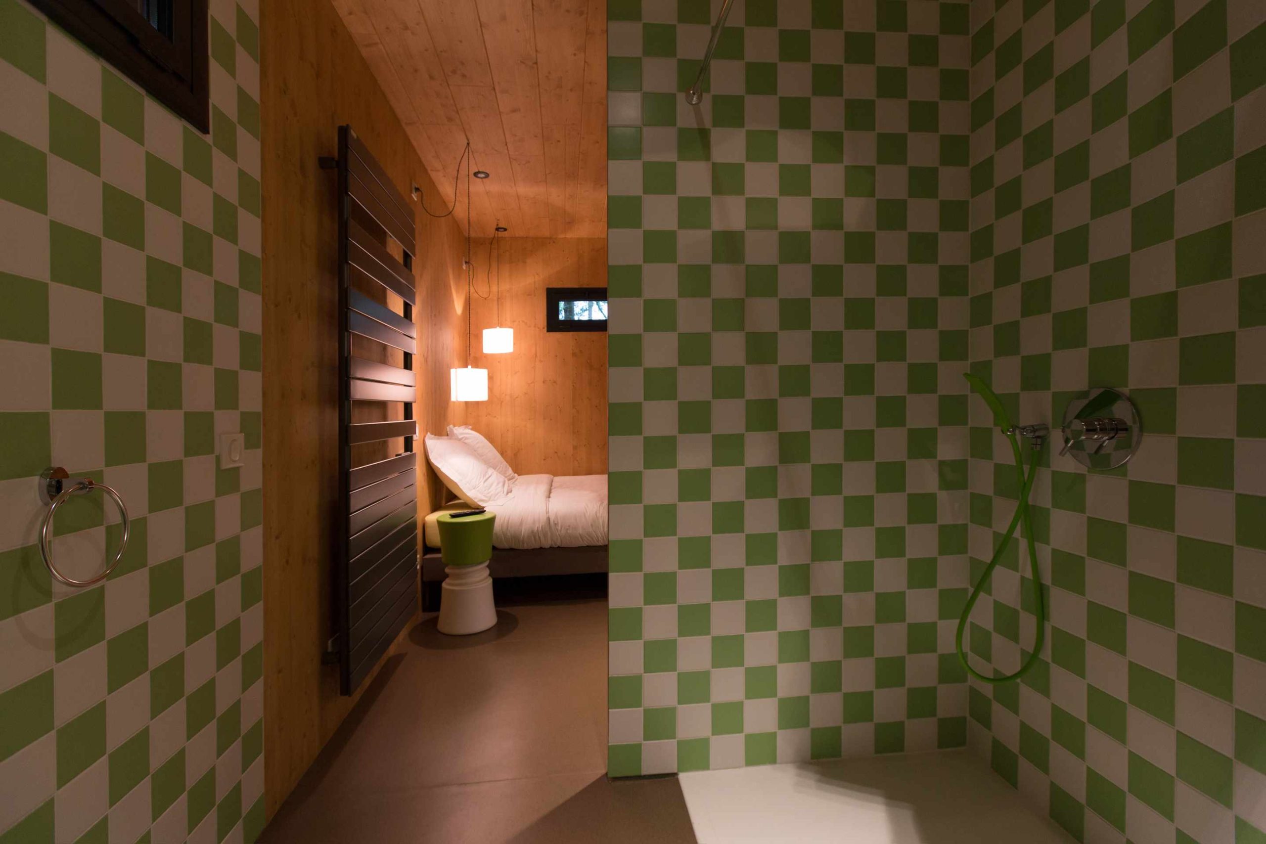 E98A7948 Hébergement insolite à Limousin : cabane moderne avec murs à carreaux verts et blancs.