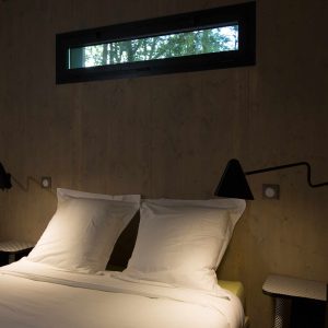 Chambre moderne dans un hébergement insolite à Limousin, avec fenêtre panoramique.