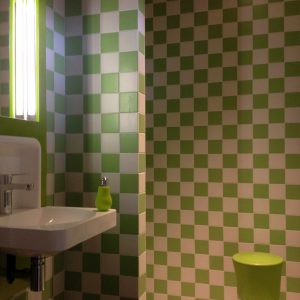 Salle de bain moderne dun hébergement insolite à Limousin, carrelage vert et blanc.