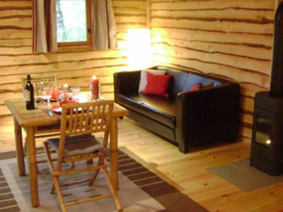 Cabane en bois à Midi-Pyrénées, avec un salon cosy et une table en bois.