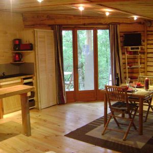 Cabane en bois dans les Midi-Pyrénées, avec un intérieur chaleureux et lumineux.