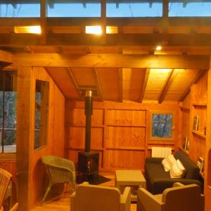 Cabane en bois chaleureuse en Aquitaine, avec poêle à bois et vue sur la nature.