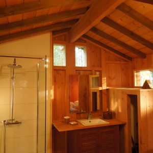 Cabane en bois avec un intérieur lumineux et des fenêtres en hauteur.