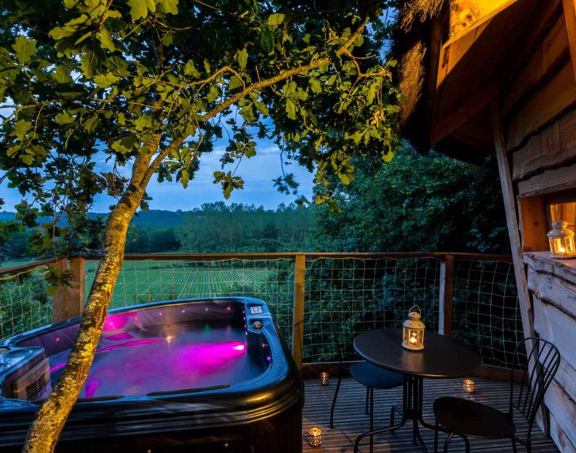 Cabane perchée avec jacuzzi, offrant une vue sur la nature environnante.