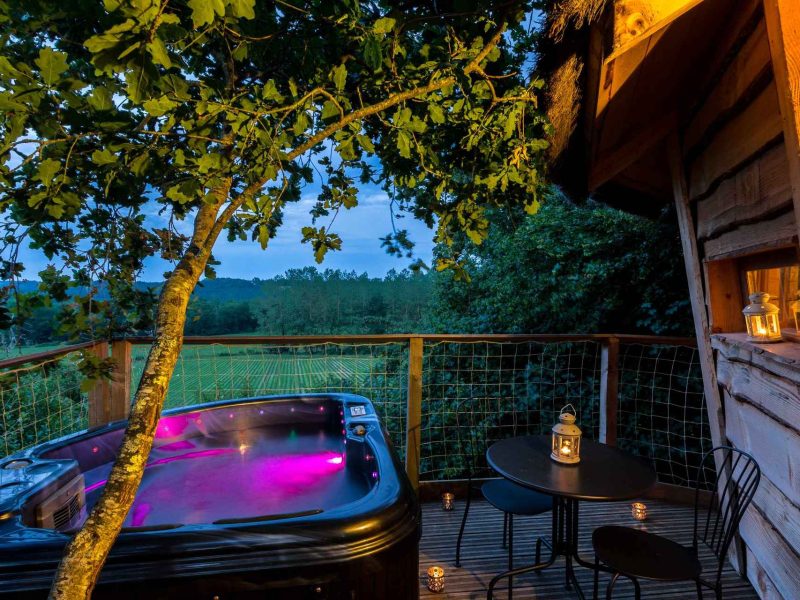 Cabane perchée avec jacuzzi, offrant une vue sur la nature environnante.