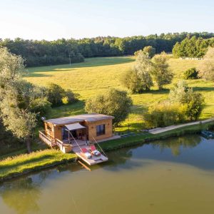 Cabane sur pilotis au bord dun lac, entourée de verdure en Aquitaine.