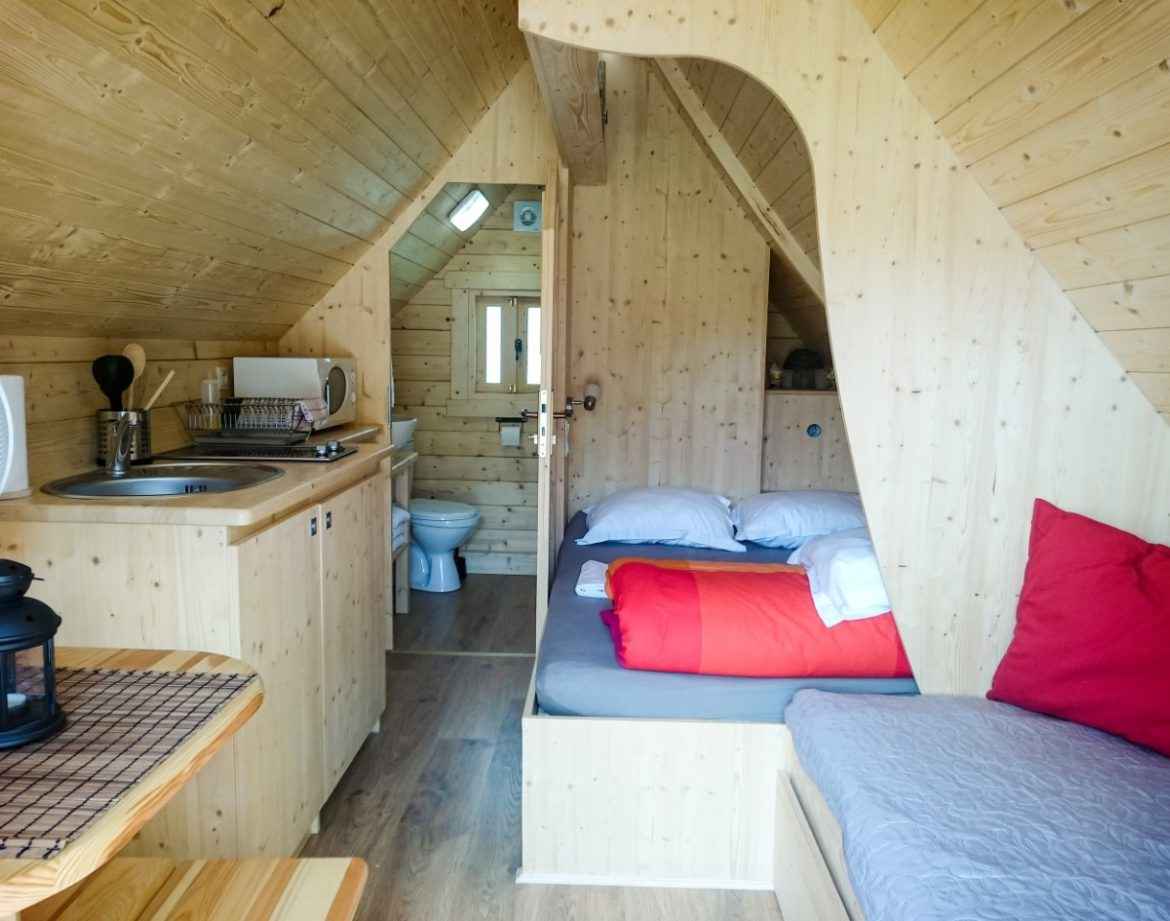 Cabane en bois cosy avec lit douillet et cuisine intégrée. Parfait pour un séjour insolite.