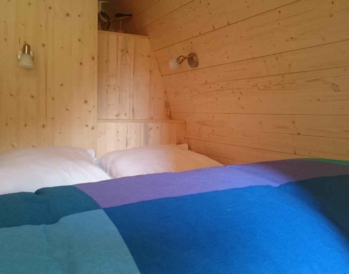 Chalet en bois chaleureux avec lit douillet et murs en panneaux de pin.