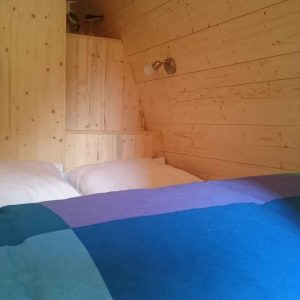 Chalet en bois chaleureux avec lit douillet et murs en panneaux de pin.