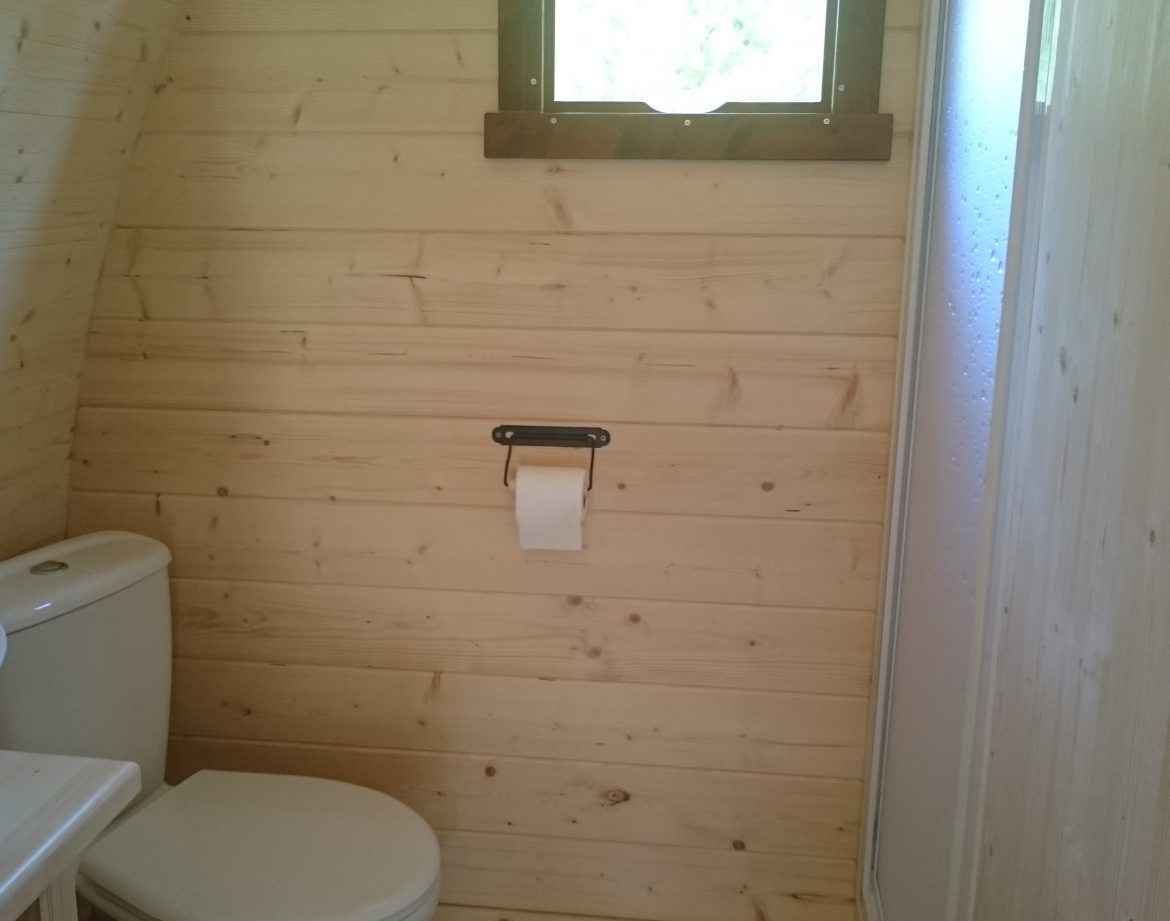 Toilettes en bois dans un hébergement insolite au Centre, ambiance naturelle et chaleureuse.