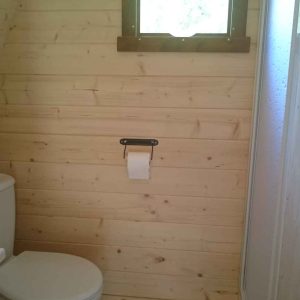Toilettes en bois dans un hébergement insolite au Centre, ambiance naturelle et chaleureuse.
