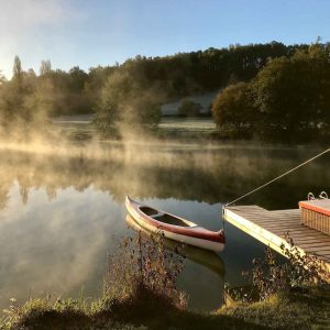 Canoë sur un lac brumeux, hébergement insolite en Aquitaine, cadre paisible.