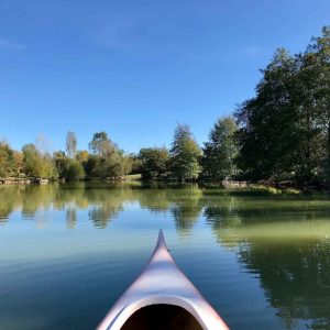 Canoë sur un lac paisible, entouré darbres verdoyants en Aquitaine.