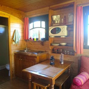 Cabane en bois cosy avec kitchenette et vue sur la nature environnante.