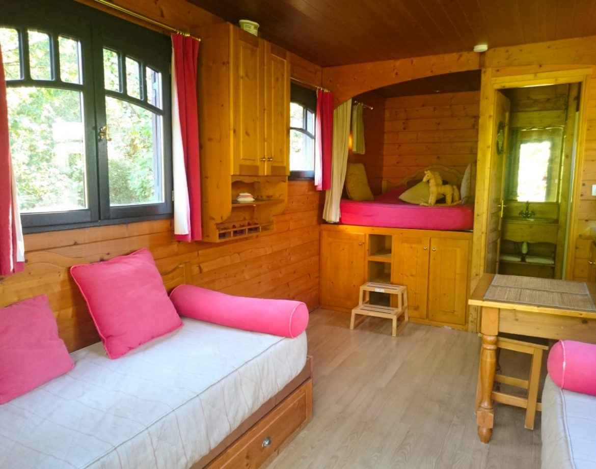 Chalet en bois chaleureux avec lits douillets et décor en bois naturel.