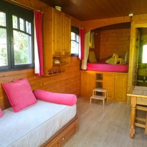 Chalet en bois chaleureux avec lits douillets et décor en bois naturel.