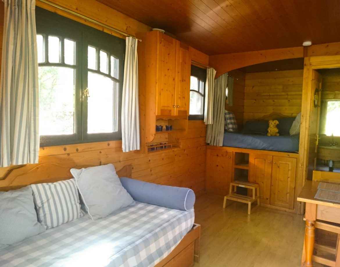 Cabane en bois cosy avec lits superposés et fenêtres lumineuses. Parfait pour un séjour unique.