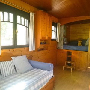 Cabane en bois cosy avec lits superposés et fenêtres lumineuses. Parfait pour un séjour unique.