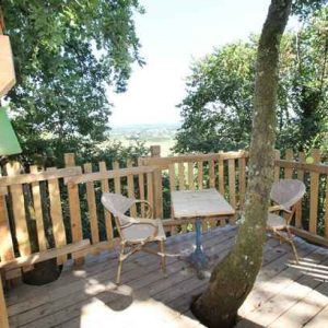 Cabane perchée en Aquitaine avec terrasse en bois et vue dégagée sur la nature.