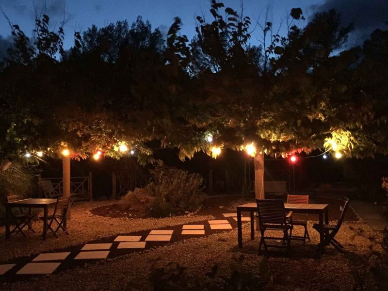 Charmant gîte en pleine nature, éclairé par des guirlandes lumineuses.