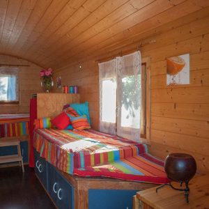 Chalet en bois coloré avec lits jumeaux et décoration chaleureuse à Provence-Alpes-Côte dAzur.