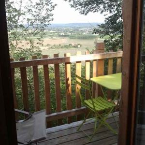 Cabane perchée en Aquitaine avec terrasse en bois et vue panoramique sur la vallée.