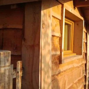 Cabane en bois dans un cadre naturel, avec une fenêtre chaleureuse.