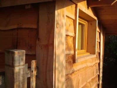 Cabane en bois dans un cadre naturel, avec une fenêtre chaleureuse.