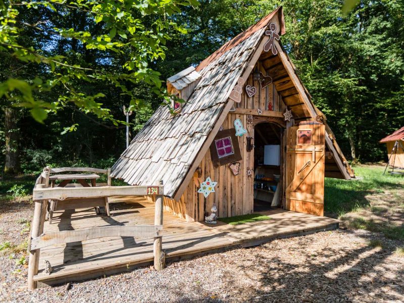 Cabane en bois originale en Alsace, avec un toit en pente et décorations colorées.